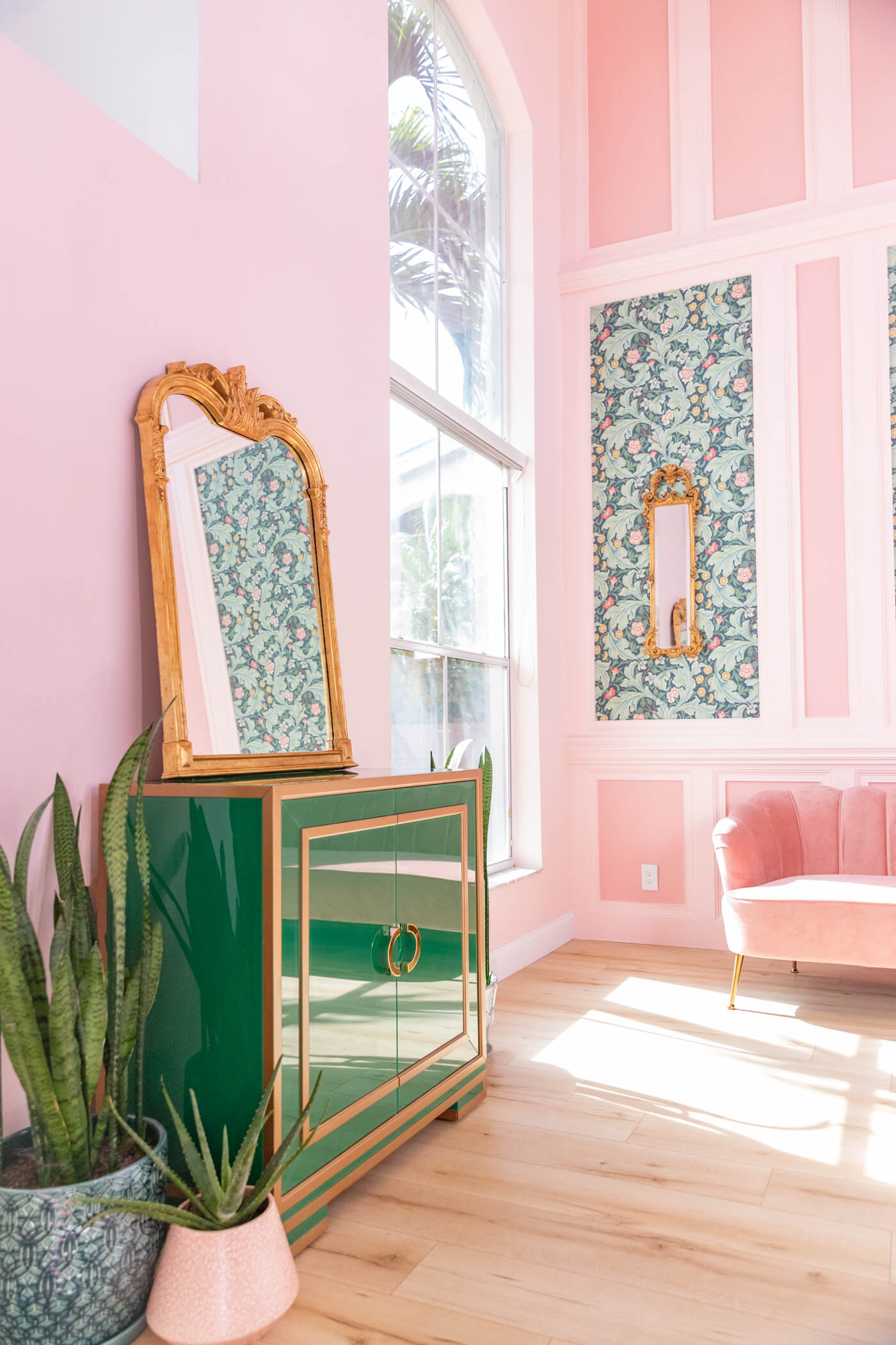 a pink and green living room with pale pink walls