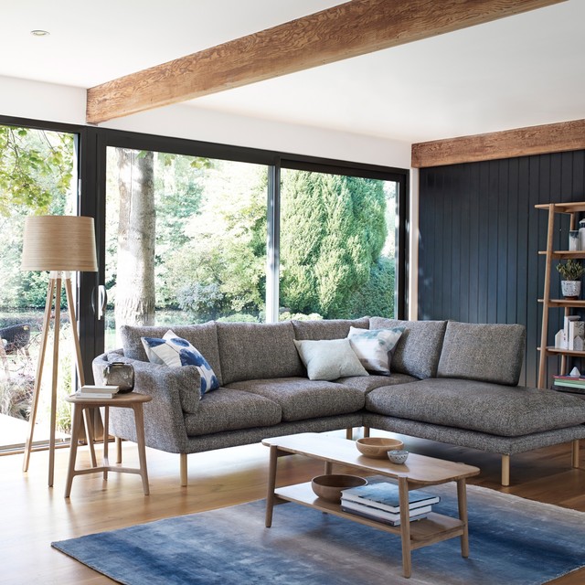 living room with modern scandinavian navy blue couch with light wood accents