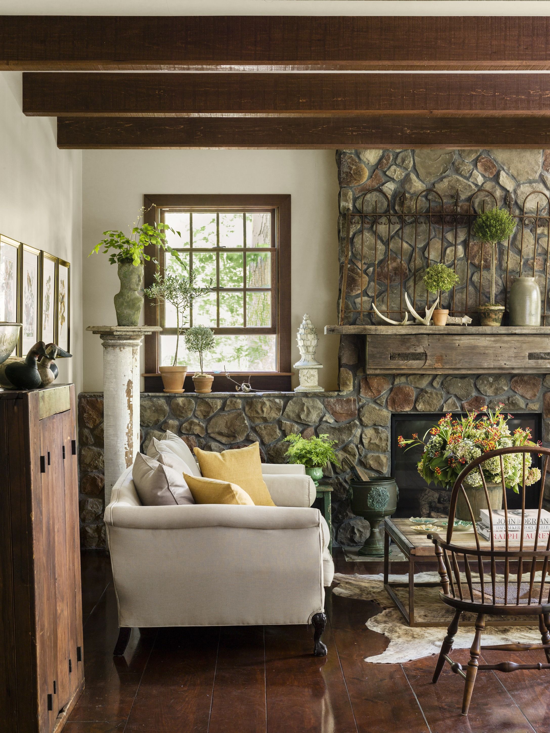 living room with rustic chic green and brown color palette with stone fireplace