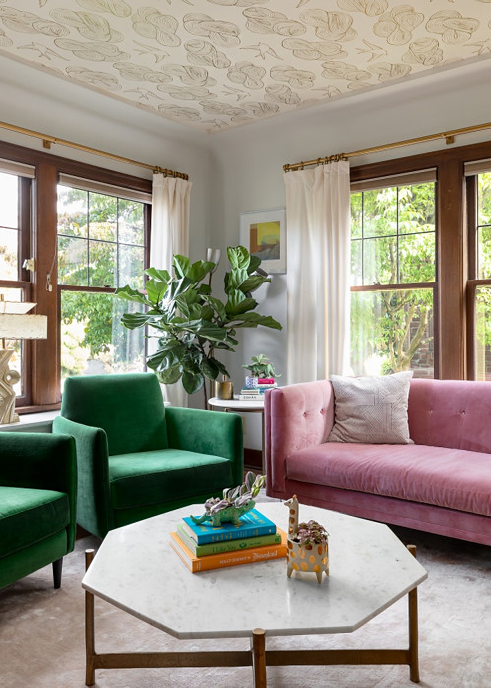 a pink and green living room with green accent chairs