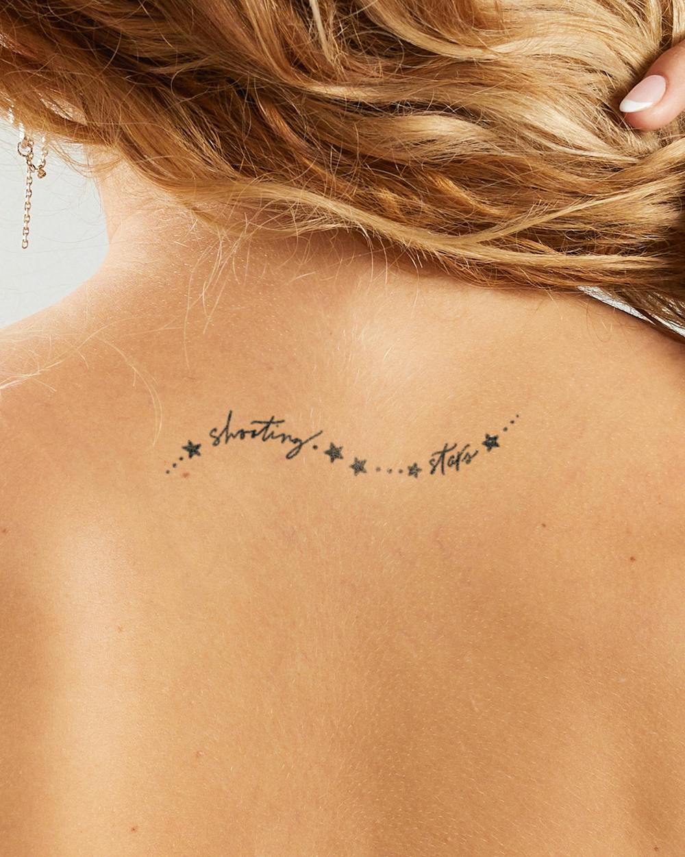 a shooting star tattoo with gold ink
