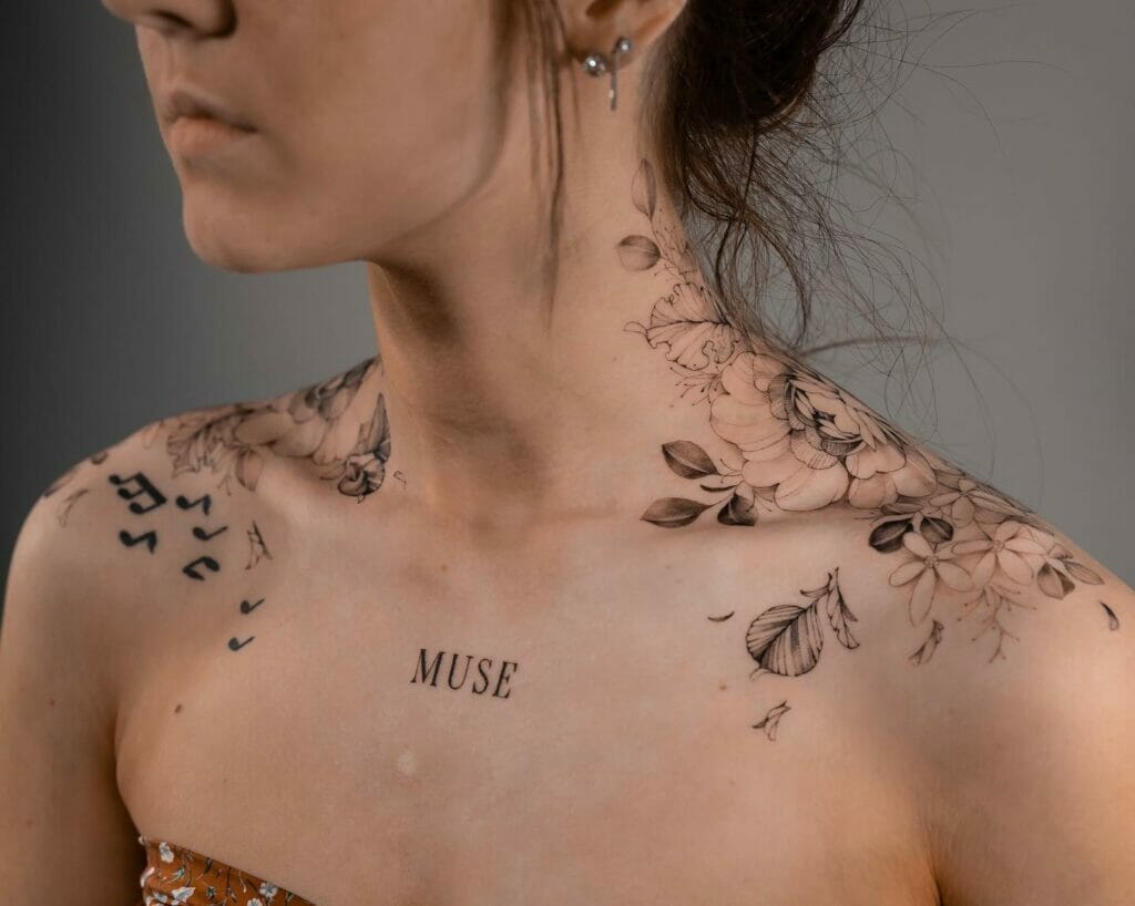 Delicate botanical elements dance across the collarbones in this ethereal fine-line masterpiece, where flowing florals meet scattered geometric shapes and meaningful text. The word 