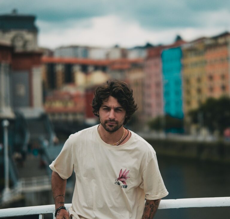 A man standing on a bridge next to a body of water