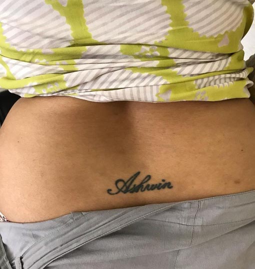 Delicate script flows across sun-kissed skin like poetry written in permanent ink, with 